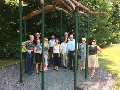Bild vergr&ouml;&szlig;ern: Ines Veith (Projektinitiatorin, vierte v. l.) mit den Mitgliedern der LEADER-Aktionsgruppe unter der Eingangsskulptur &raquo;Getrennt wurzeln, gemeinsam wachsen&laquo; - dem Motto des SOPHI-Parks in Bad Liebenzell.